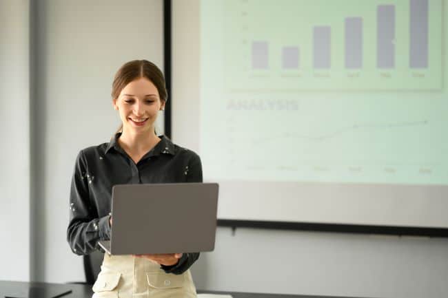 Usmiechajaca sie kobieta ktora ukonczyla kurs Powerpoint przedstawia prezentacje 1