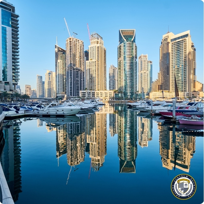 Panorama nowoczesnych wieżowców Dubaju odbijających się w wodzie zatoki z zacumowanymi jachtami w Dubai Marina - miejsce pracy stewardess Emirates.